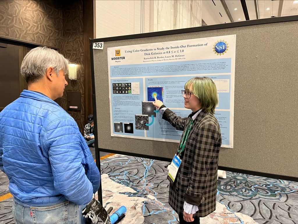 A physicist points to interesting information on her poster.
