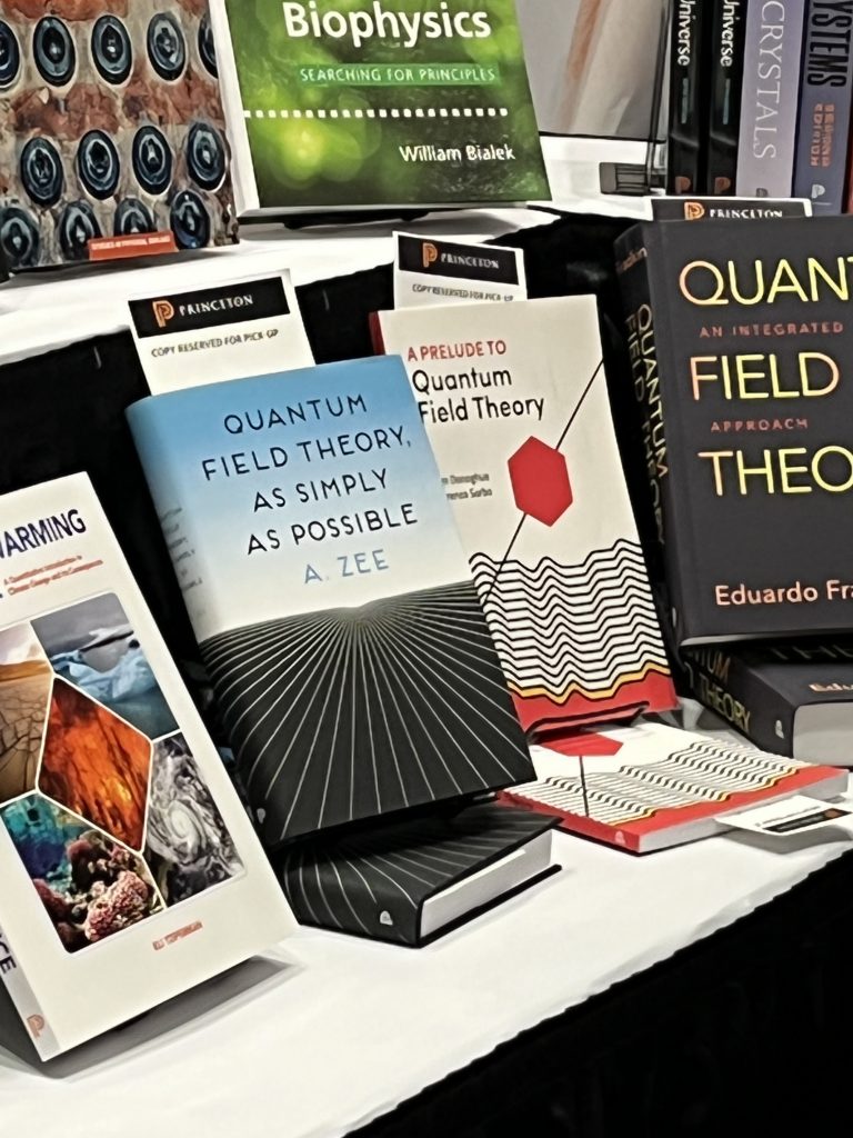 A collection of physics books is arranged on a table.